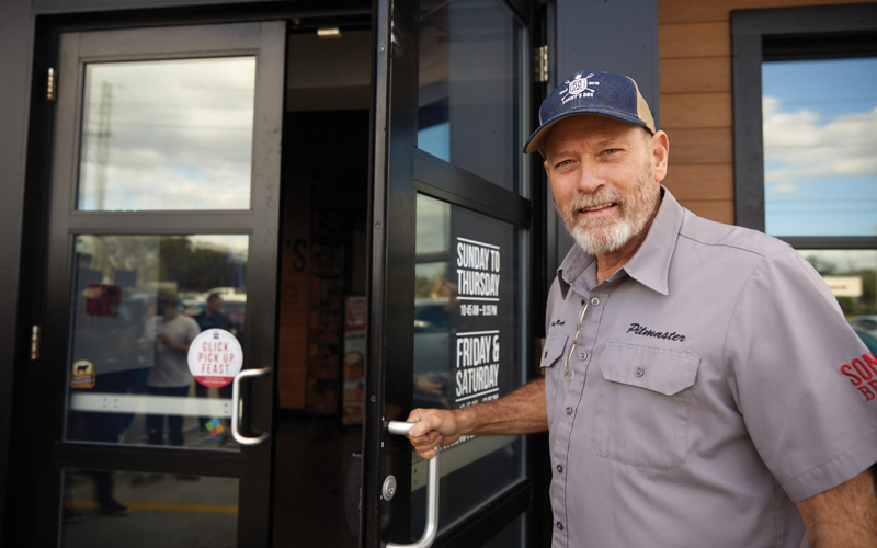 Pitmaster opening door to restaurant